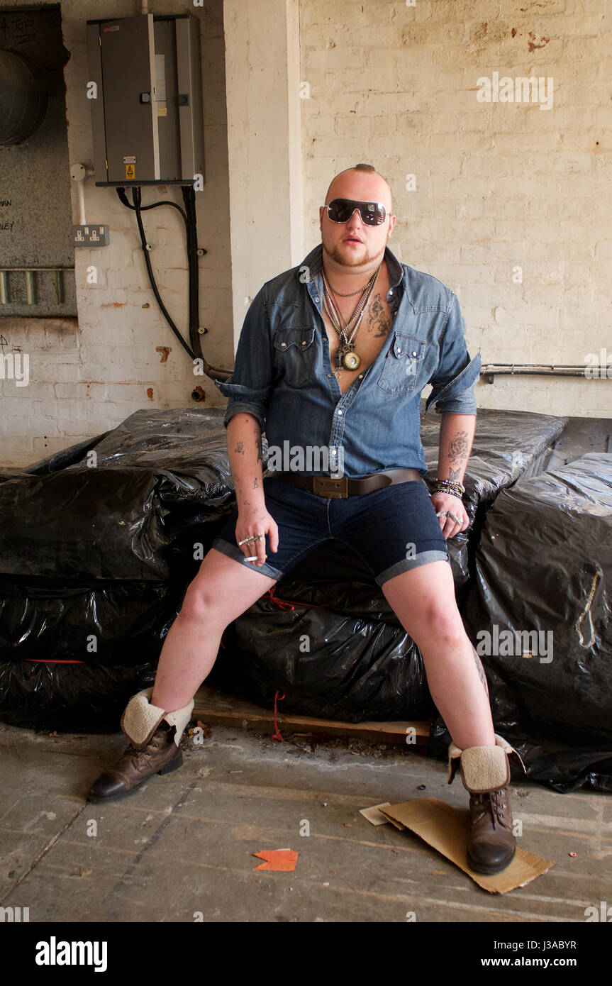 gay man wearing denim shorts and denim shirt and chains indoors Stock Photo  - Alamy