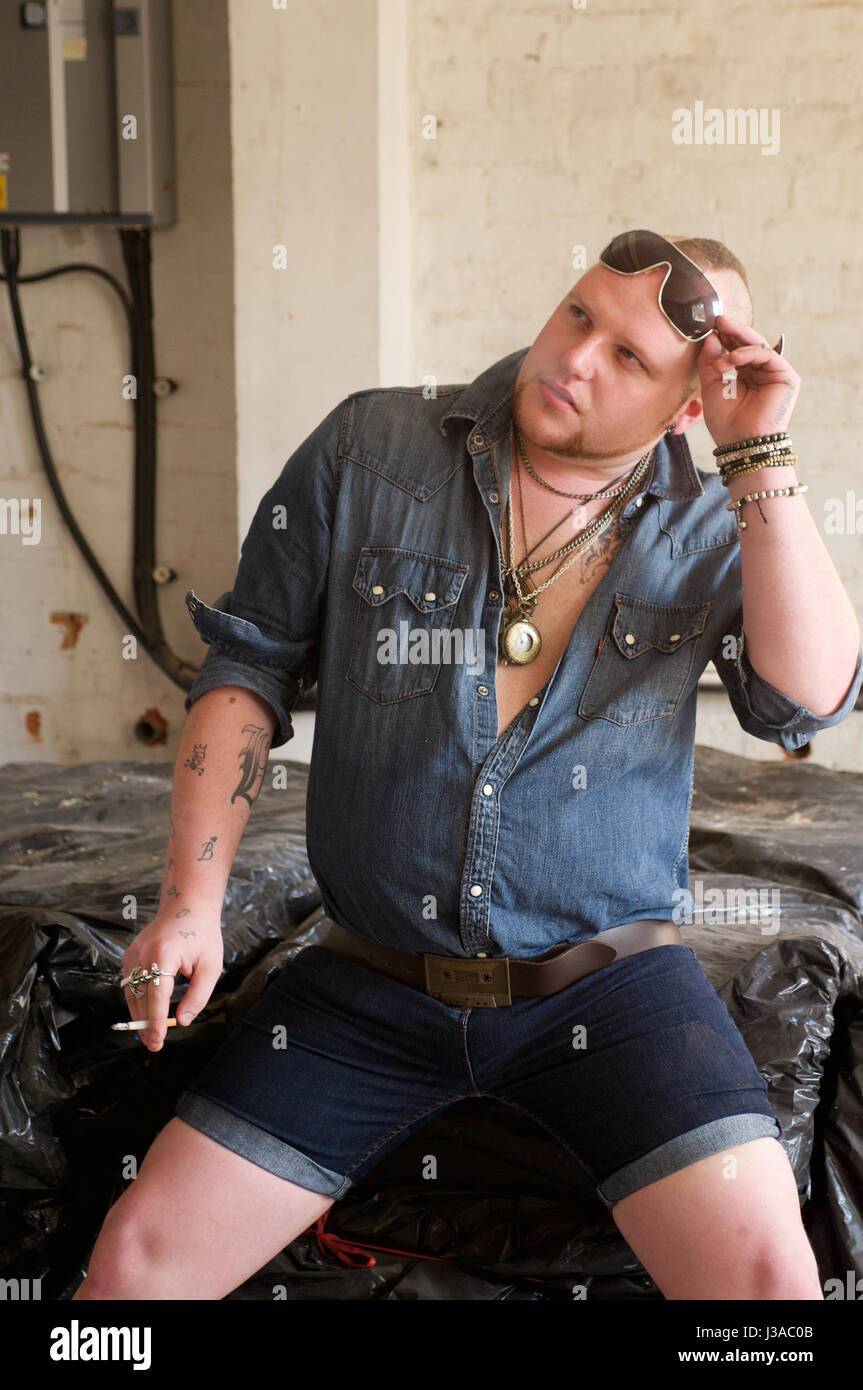 gay man wearing denim shorts and denim shirt and chains indoors Stock Photo  - Alamy