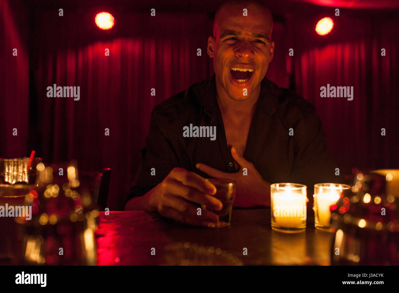 Young man enjoying a drink at a bar Stock Photo Alamy