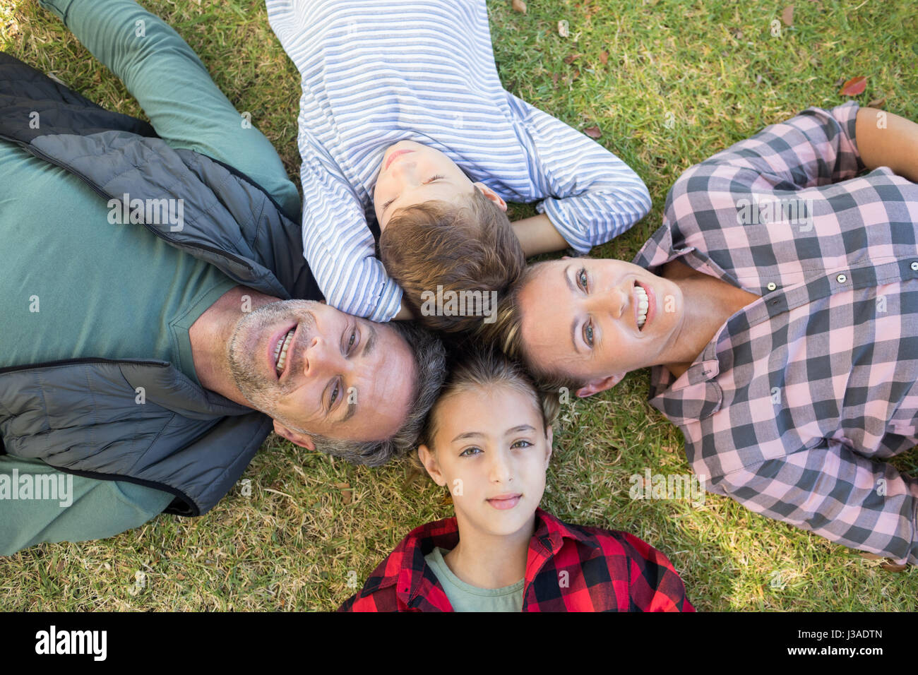 Happy family lying on the grass in park Stock Photo - Alamy