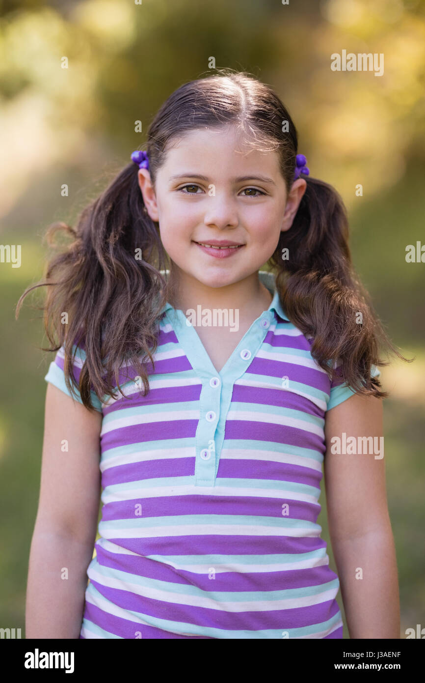 Portrait of smiling little girl standing in forest Stock Photo - Alamy