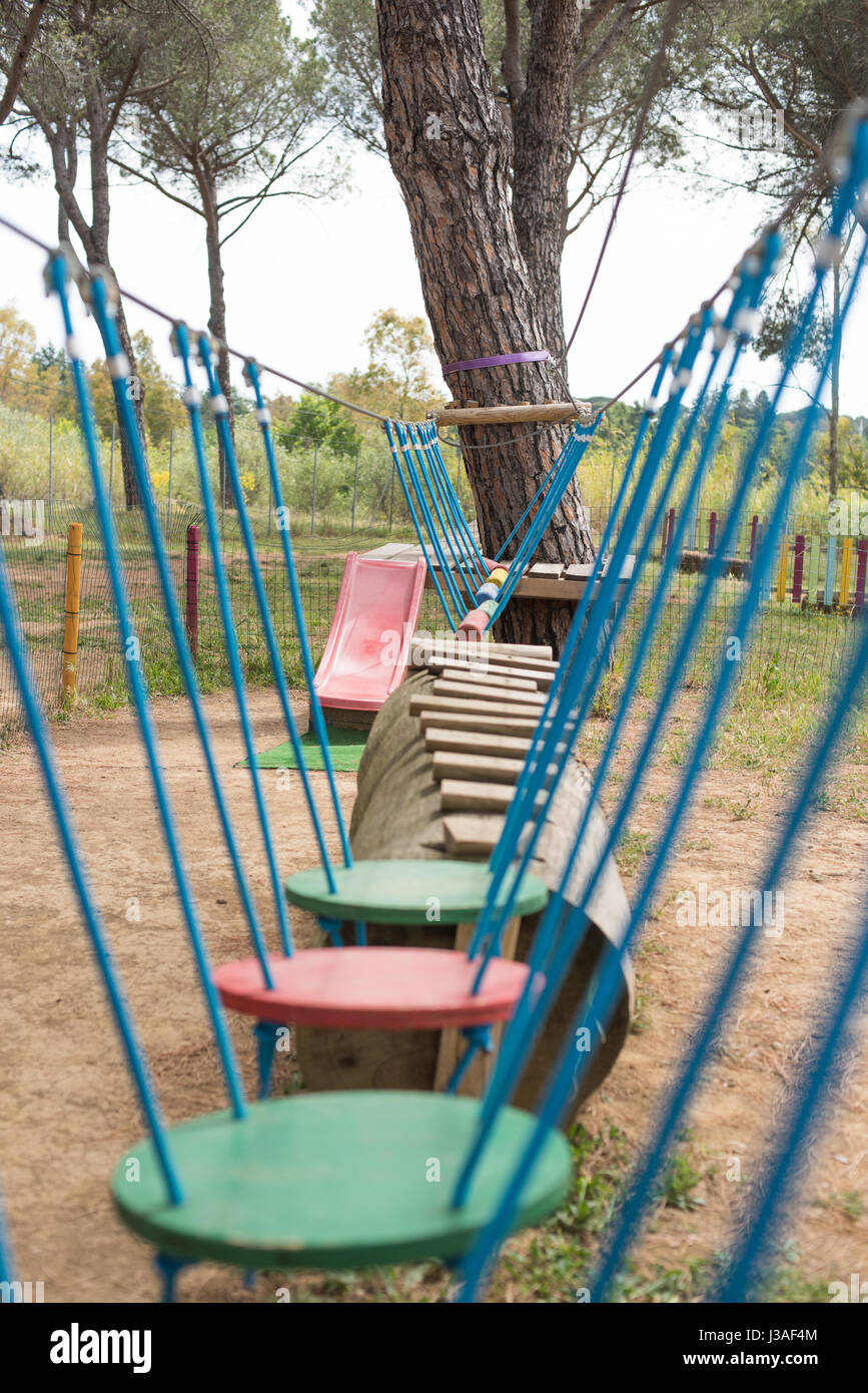 Adventure playground suspended test path, selective focus obstacle in foreground Stock Photo