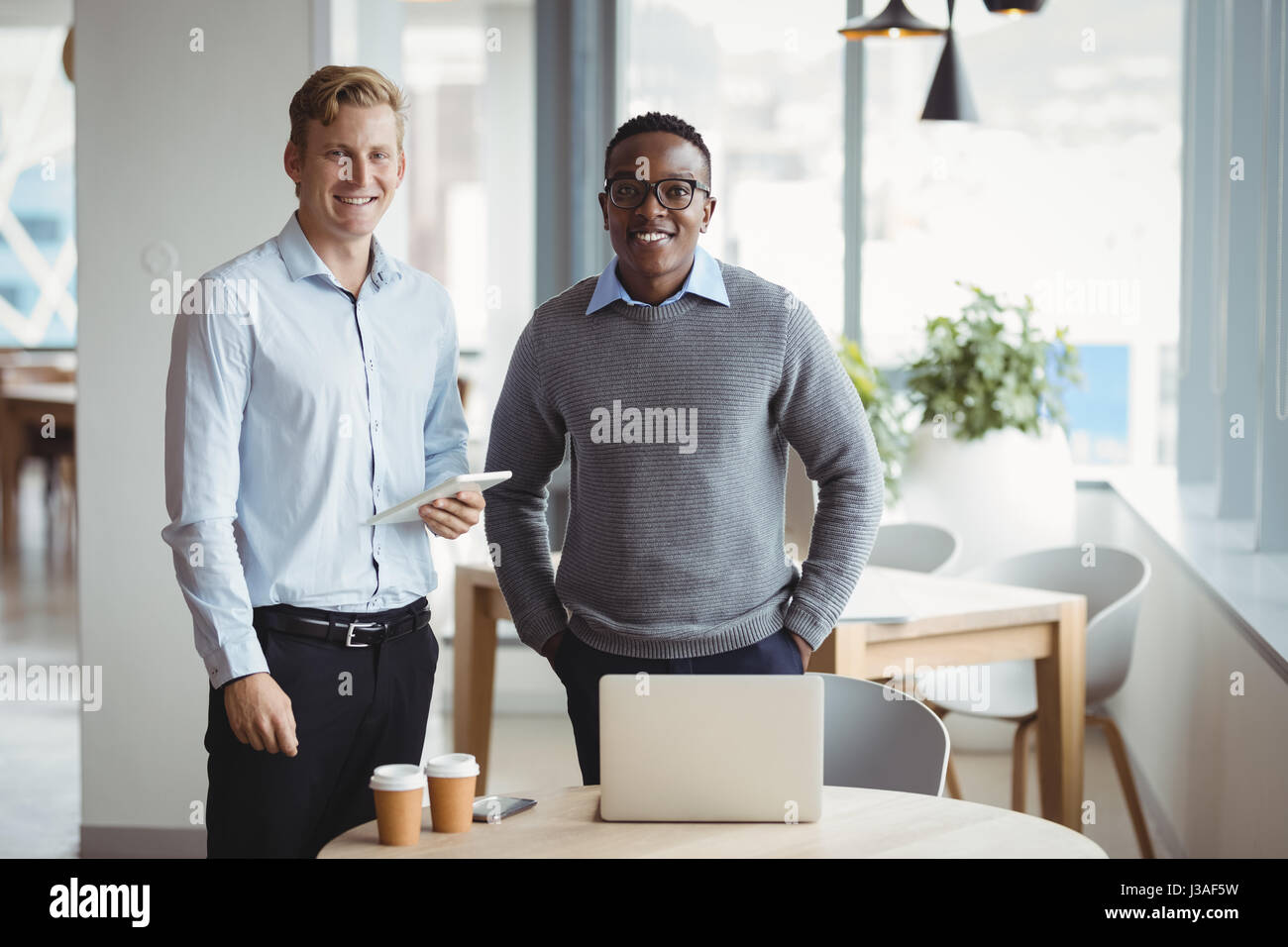 Portrait of smiling executives standing in office Stock Photo - Alamy