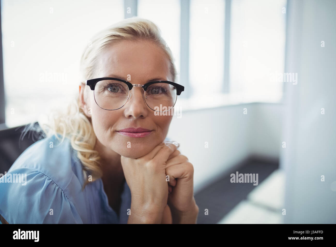 Portrait of smiling executive sitting in office Stock Photo - Alamy