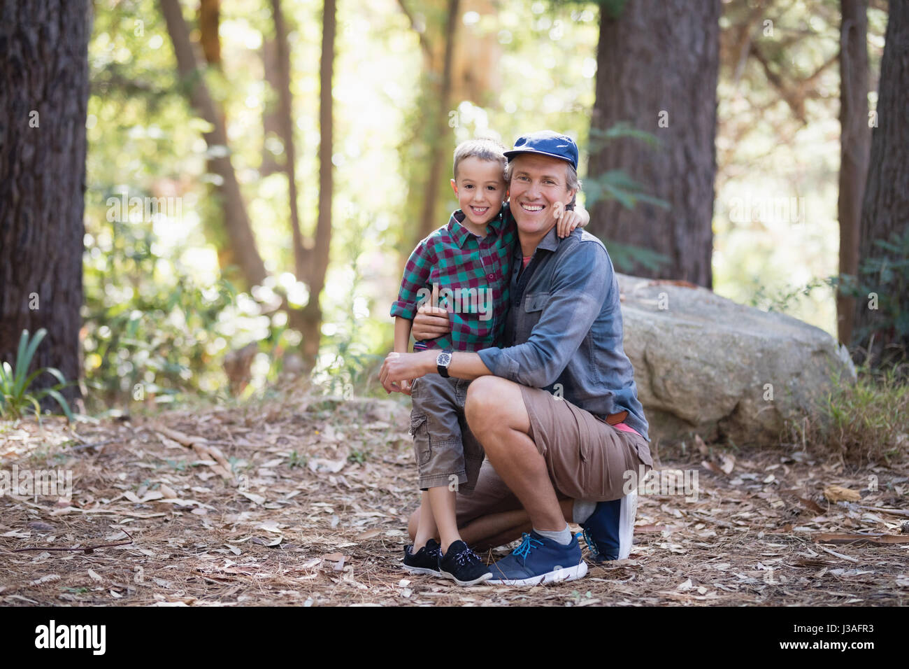 Full length portrait of smiling father and son hiking in forest Stock ...