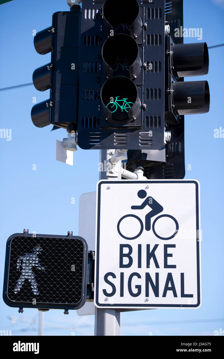 Traffic light with the included green for cyclists and pedestrians is fixed on a pole with a sign with information about what is a light signal for Stock Photo
