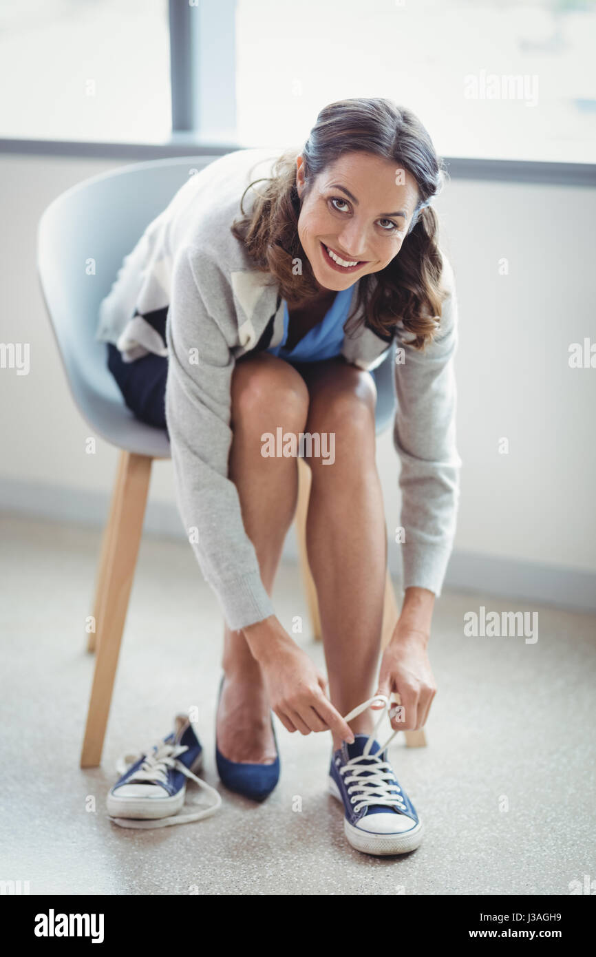 Portrait of smiling woman wearing canvas shoes in office Stock Photo Alamy