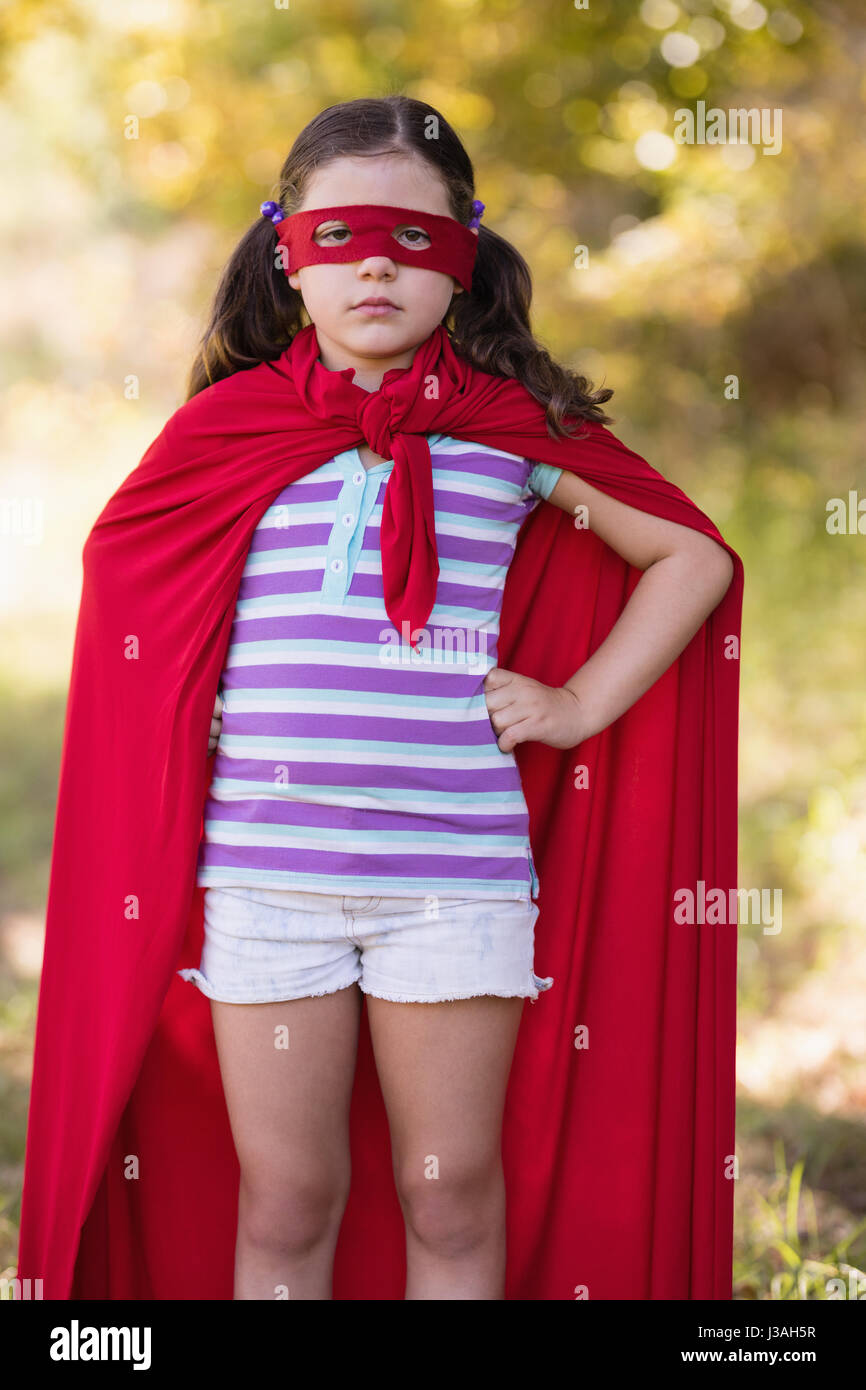 Portrait of confident little girl wearing superhero costume at campsite Stock Photo