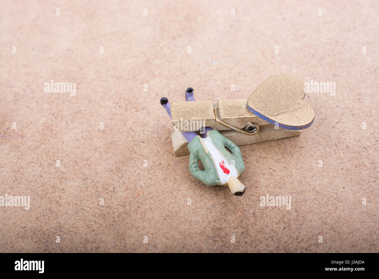 Man figurine trapped in a clothespin on ground Stock Photo Alamy