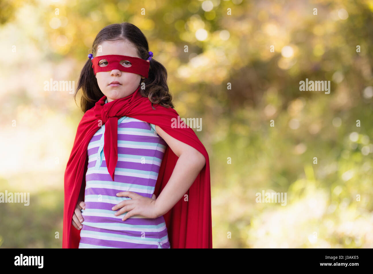 Portrait of little girl wearing superhero costume at campsite Stock Photo