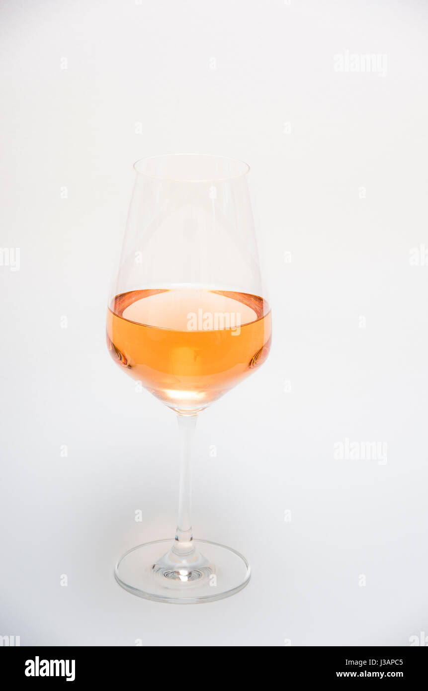 Orange wine (rosé wine) in a stem glass isolated on a white background. Stock Photo