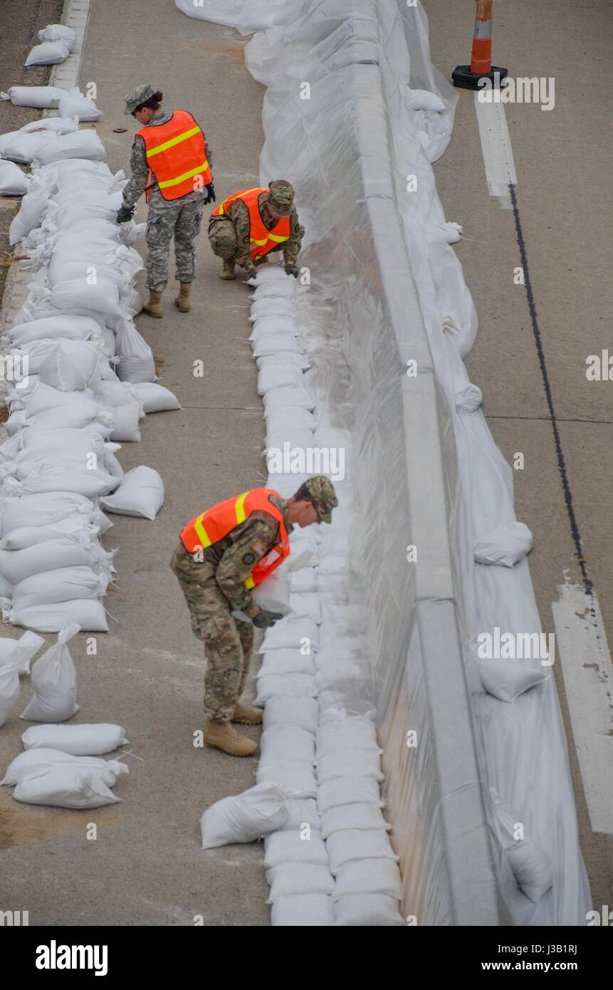 Missouri National Guardsmen work to build a support wall with sandbags to keep floodwaters away from Highway 60 May 3, 2017 in Fisk, Missouri. Historic flooding has swamped towns across Arkansas and Missouri with at least 20 people reported dead. Stock Photo