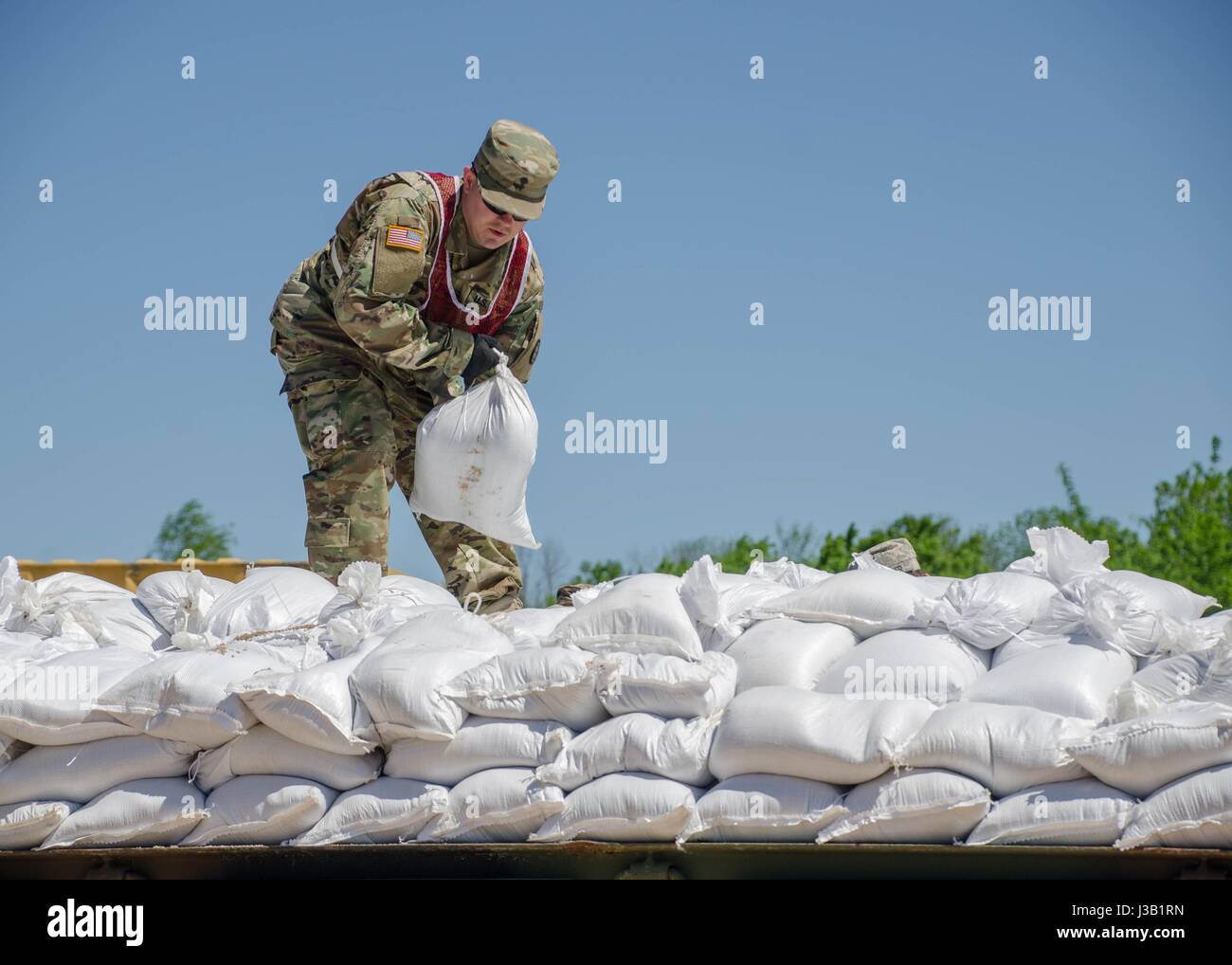 Missouri National Guardsmen work to build a support wall with sandbags to support a levee against floodwaters May 2, 2017 in Poplar Bluff, Missouri. Historic flooding has swamped towns across Arkansas and Missouri with at least 20 people reported dead. Stock Photo