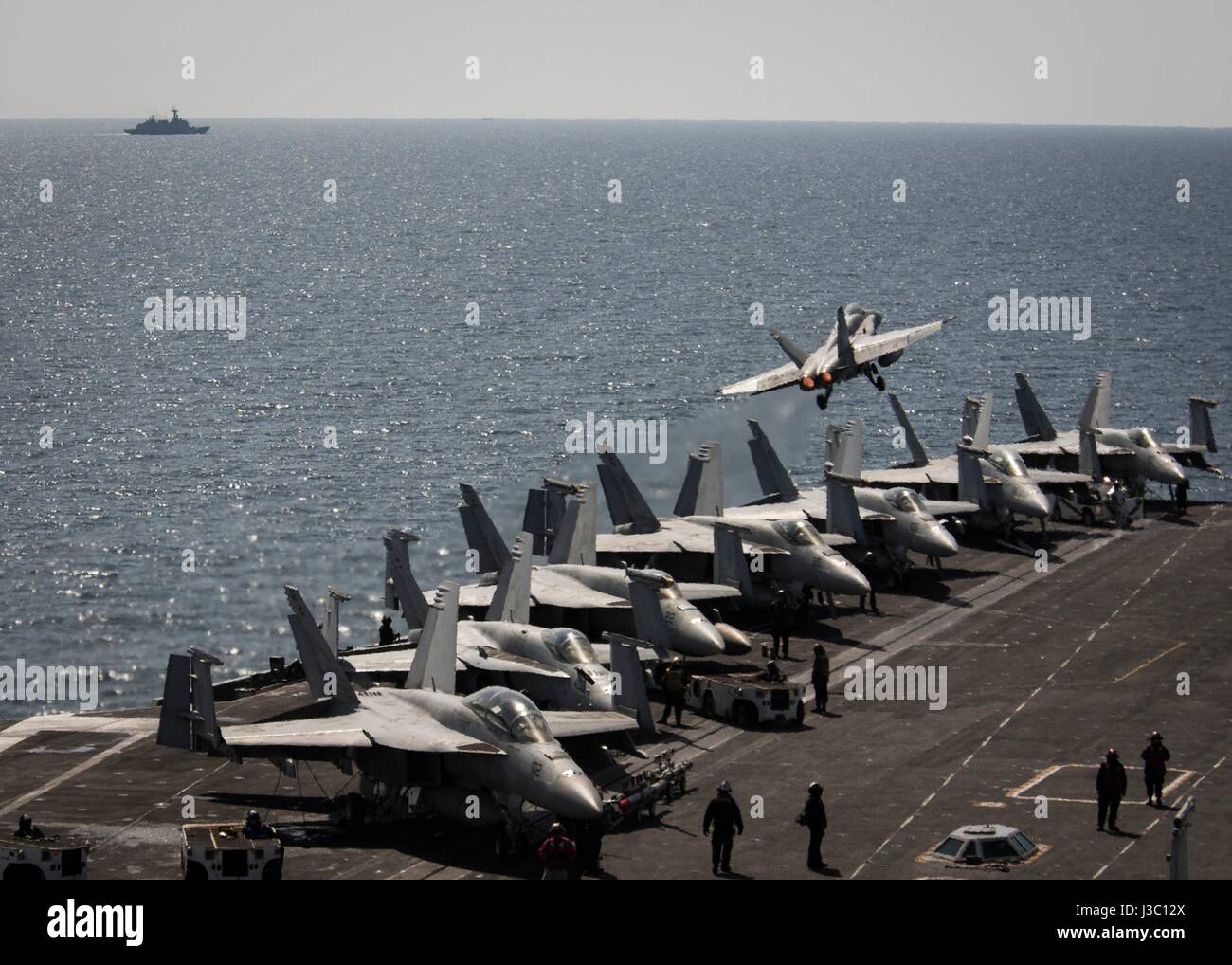 A U.S. Navy F/A-18C Super Hornet fighter from the Blue Blasters of Strike Fighter Squadron 34 takes off from the flight deck of the Nimitz-class aircraft carrier USS Carl Vinson underway with an escort of U.S. and South Korean warships during patrol May 2, 2017 off the coast of Korea. Stock Photo