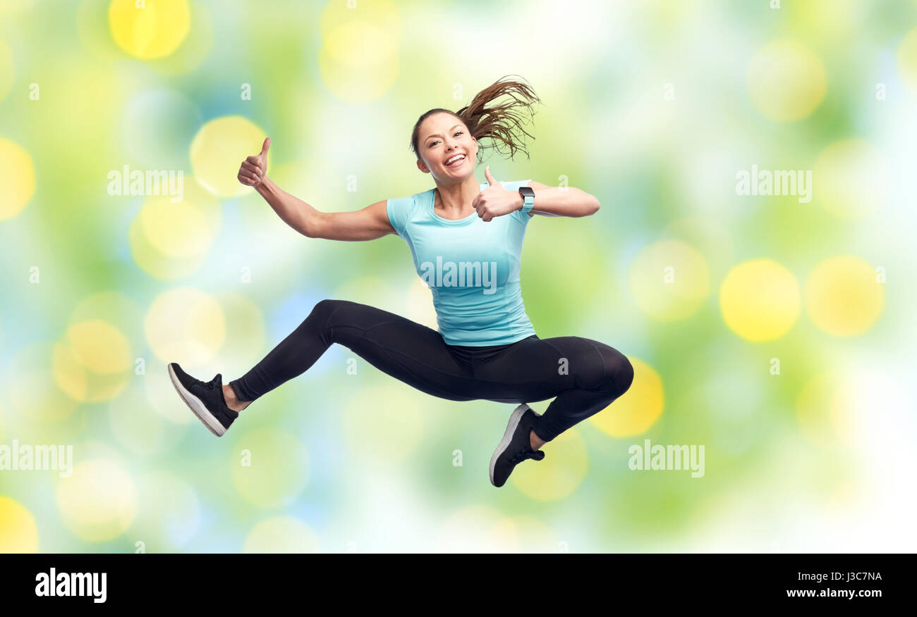 happy smiling sporty young woman jumping in air Stock Photo - Alamy