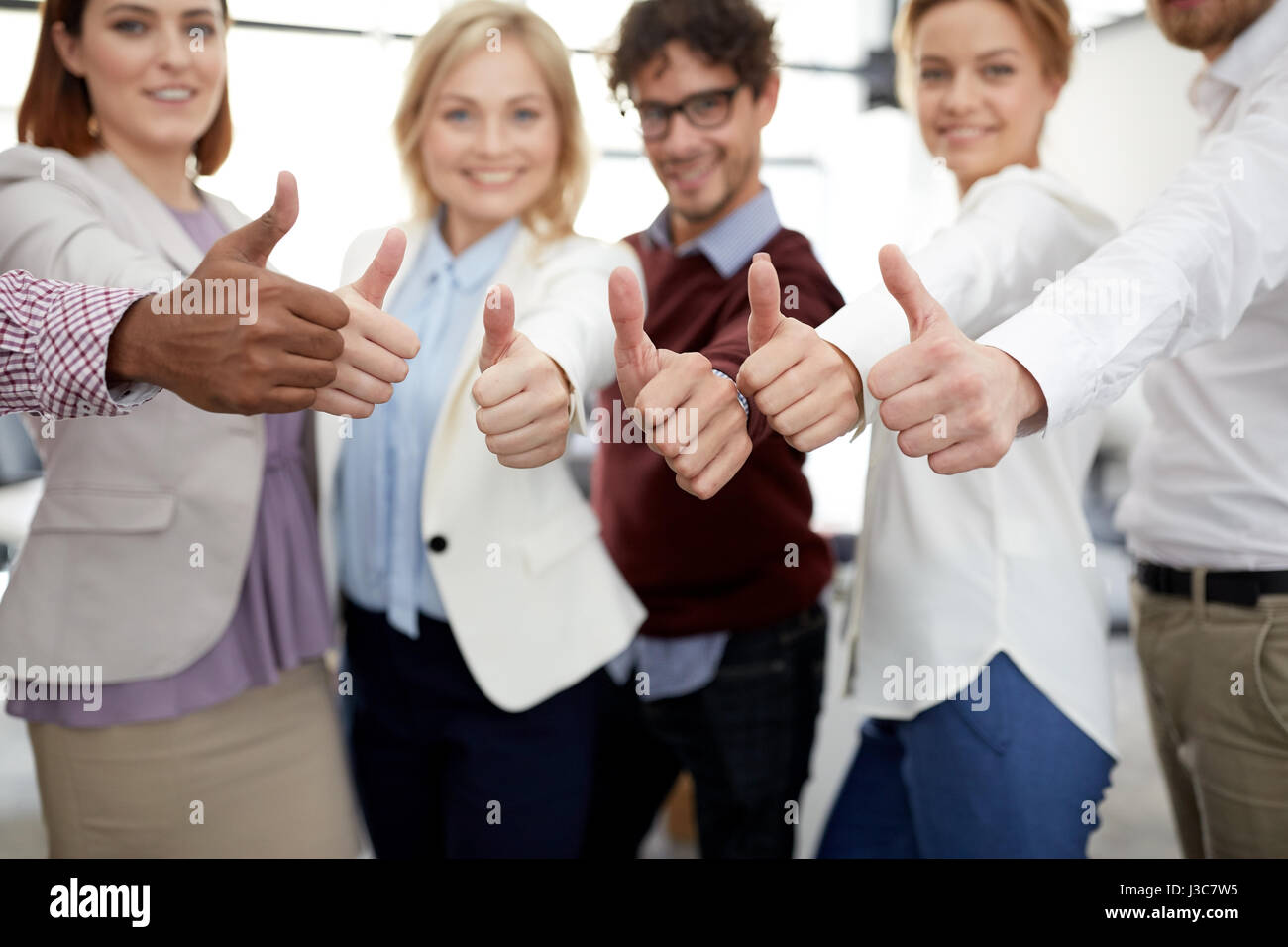happy business team showing thumbs up at office Stock Photo - Alamy