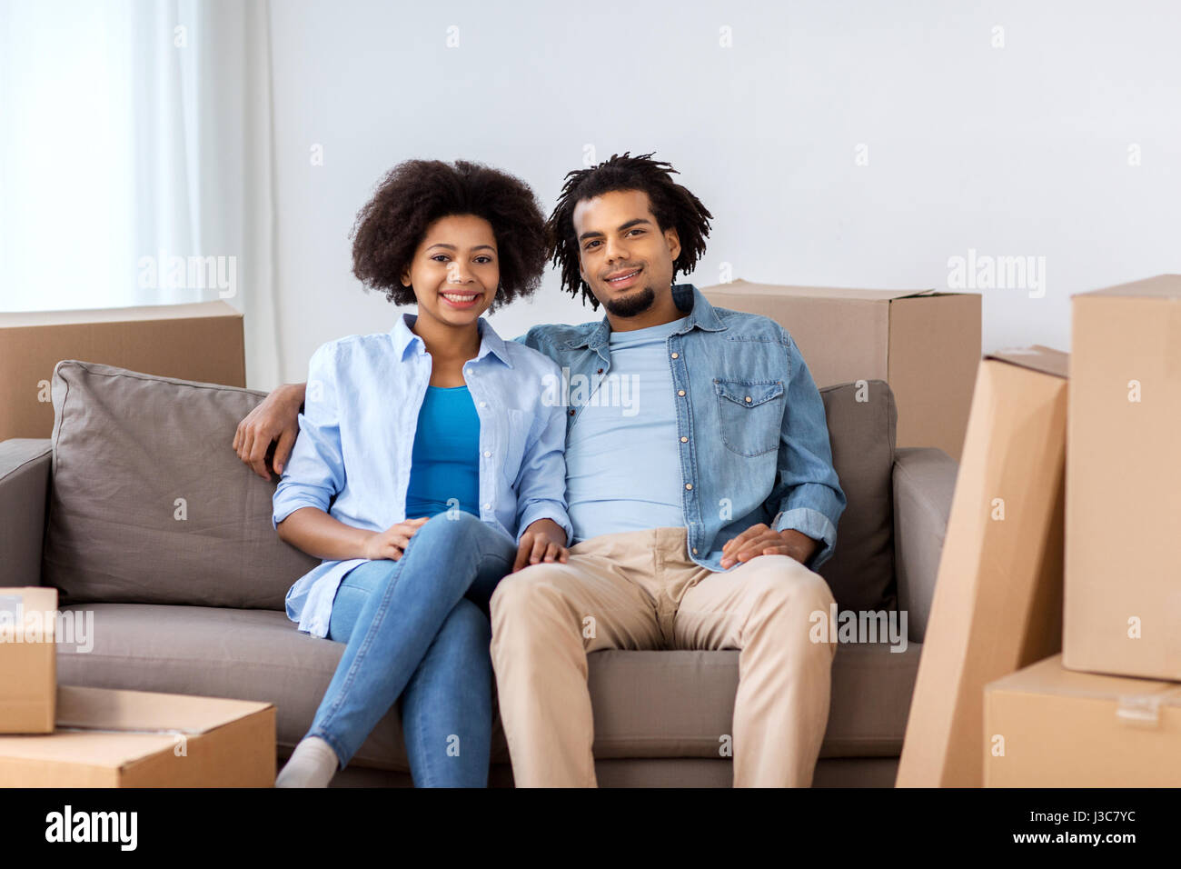 happy couple with boxes moving to new home Stock Photo - Alamy