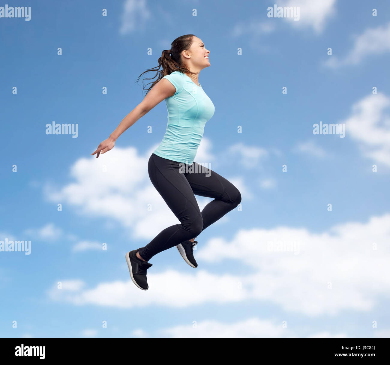 happy smiling sporty young woman jumping in sky Stock Photo - Alamy