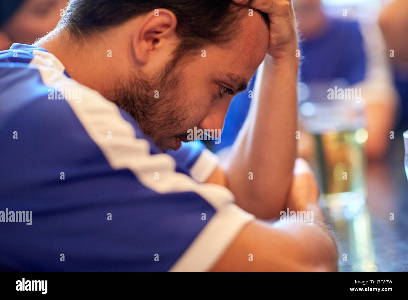 close up of sad football fan at bar or pub Stock Photo