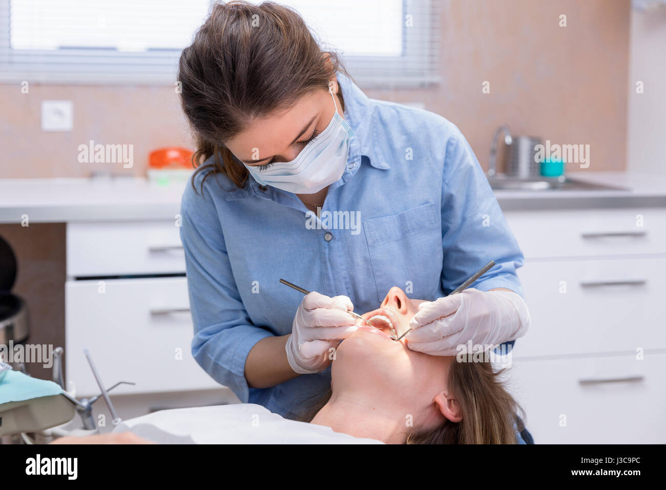 Dentist woman examining patient Stock Photo