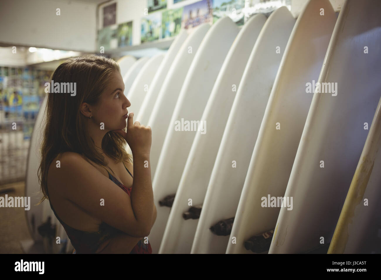 Woman Selecting A Surfboard In Beach Cabin Stock Photo 139798340