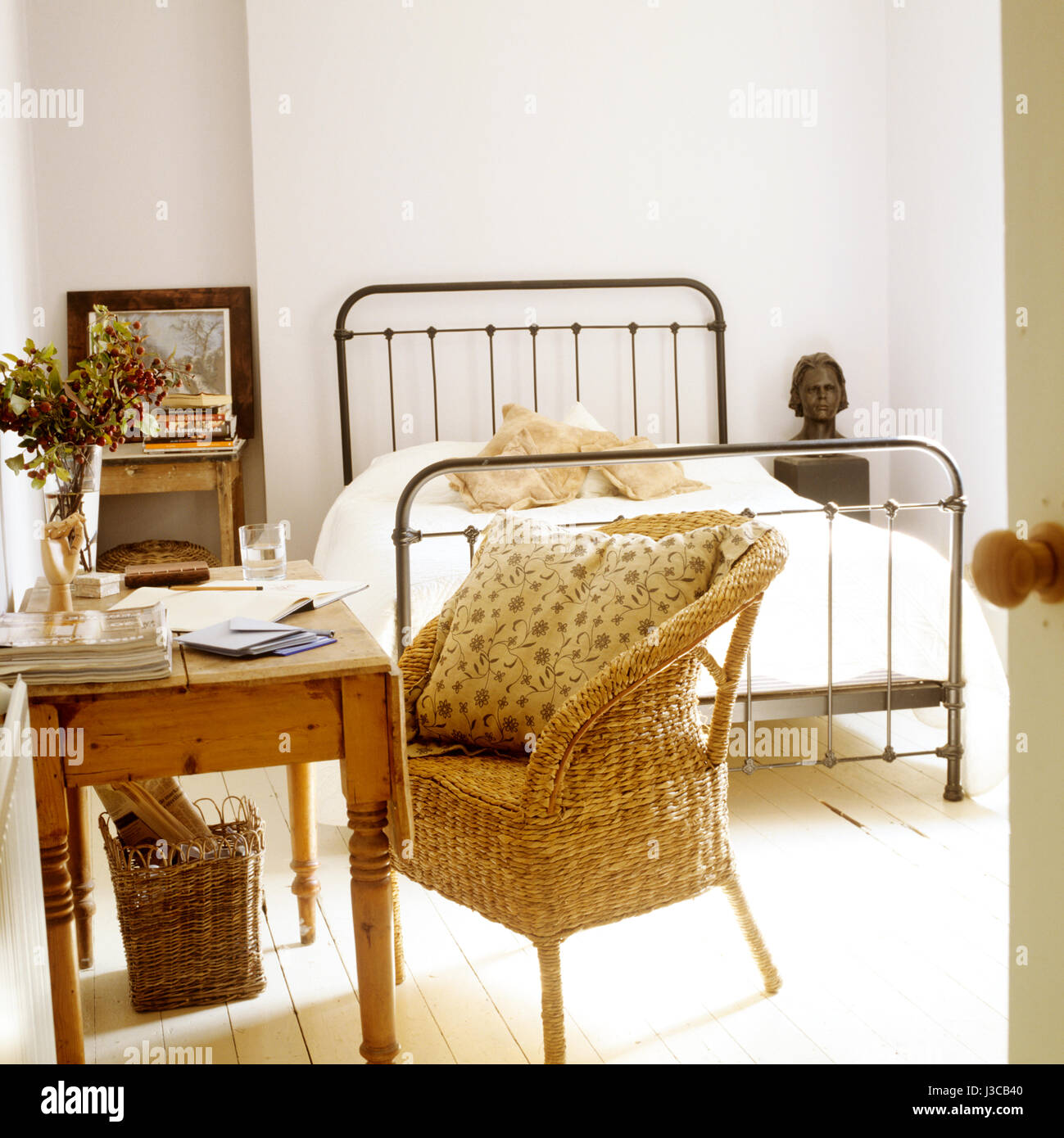 Bedroom with desk and wicker chair. Stock Photo
