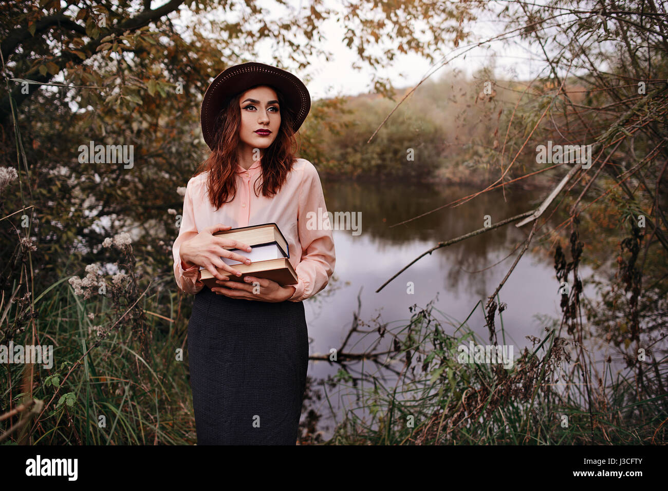 Girl-student sit on lawn and reads textbook Stock Photo - Alamy