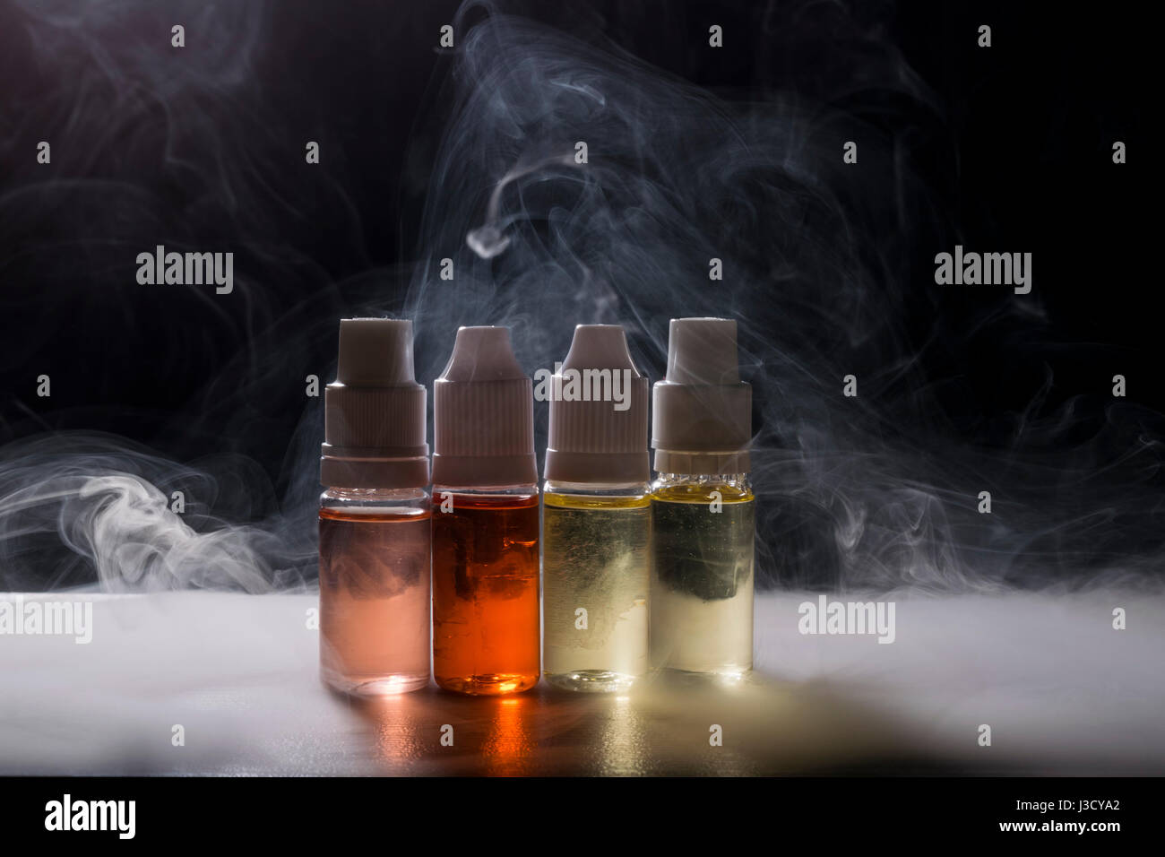 isolated e liquid  for electronic cigarette on smoke cload background. Stock Photo