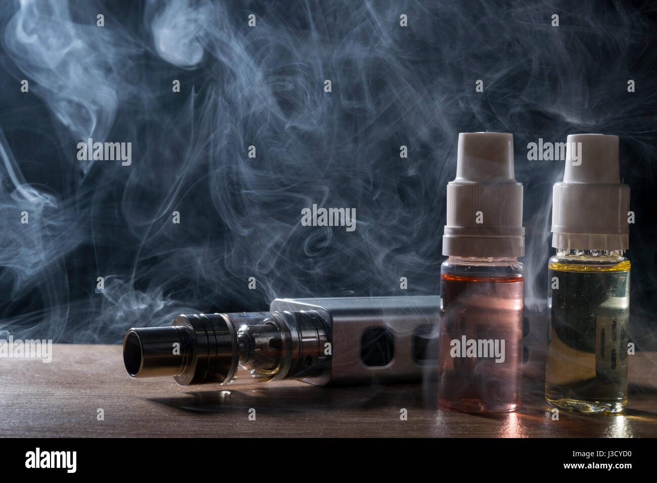 isolated e liquid and vaping device for electronic cigarette with lots of smoke Stock Photo