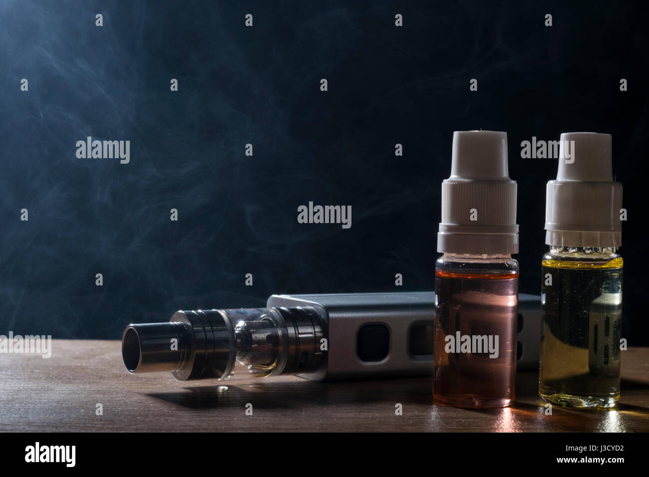 isolated e liquid drug and vaping device for electronic cigarette on a dark  background Stock Photo - Alamy