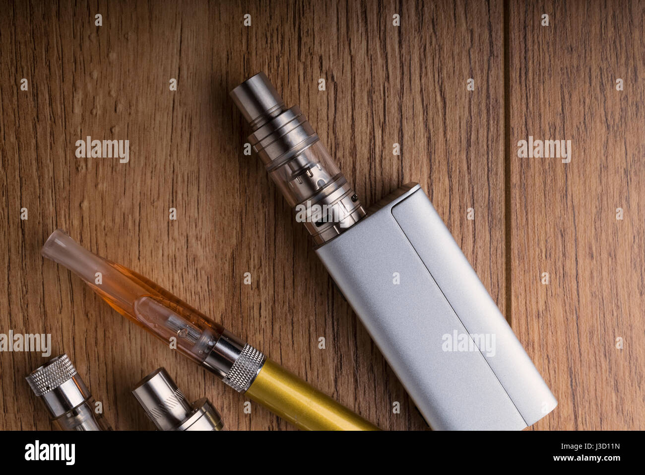 Isolated vaping devices or electronic cigarette over a wooden background. Stock Photo