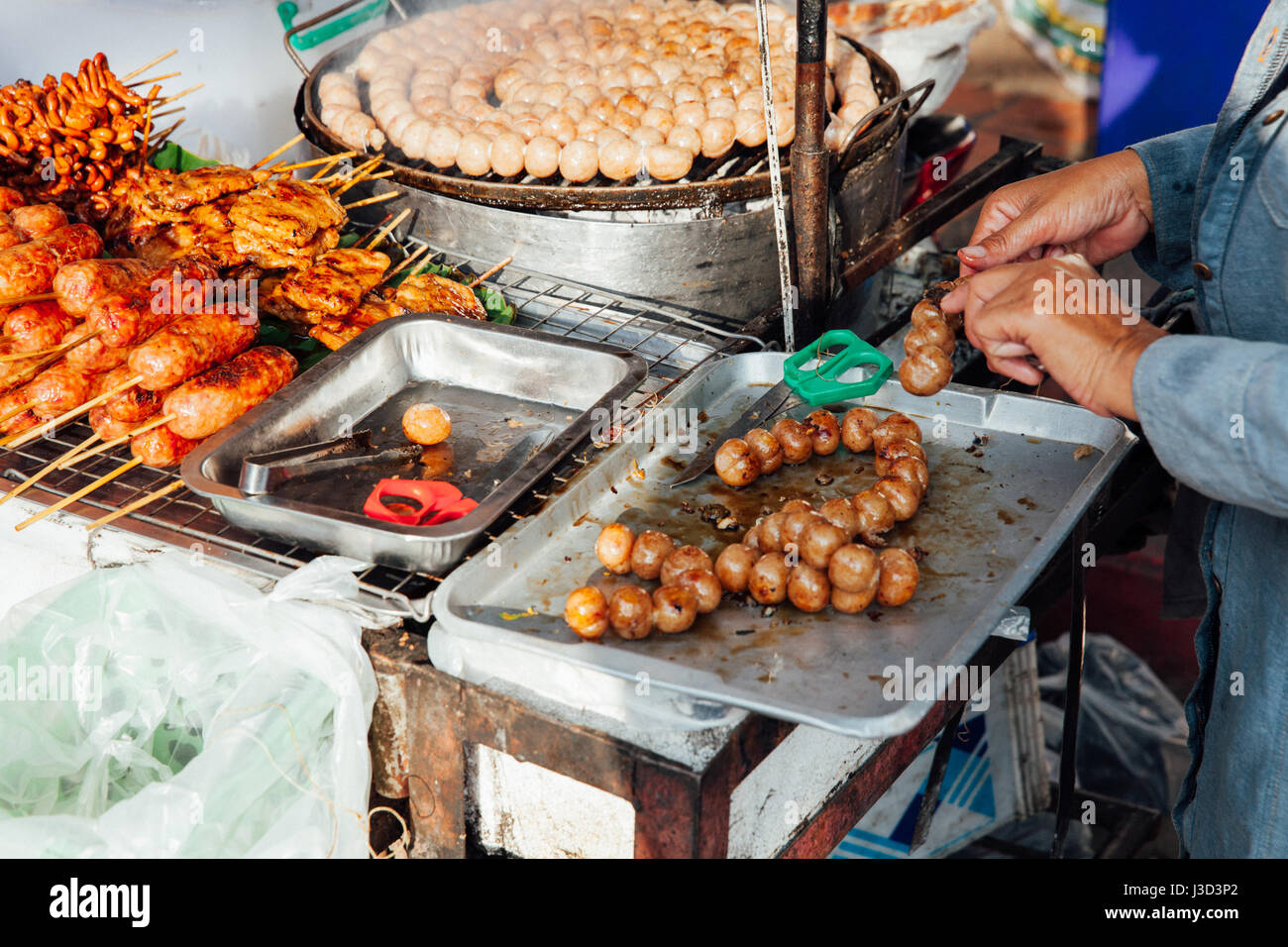CHIANG MAI, THAILAND - AUGUST 21: Thai woman cooks meatballs at the Sunday Market (Walking Street) on August 21, 2016 in Chiang Mai, Thailand. Stock Photo