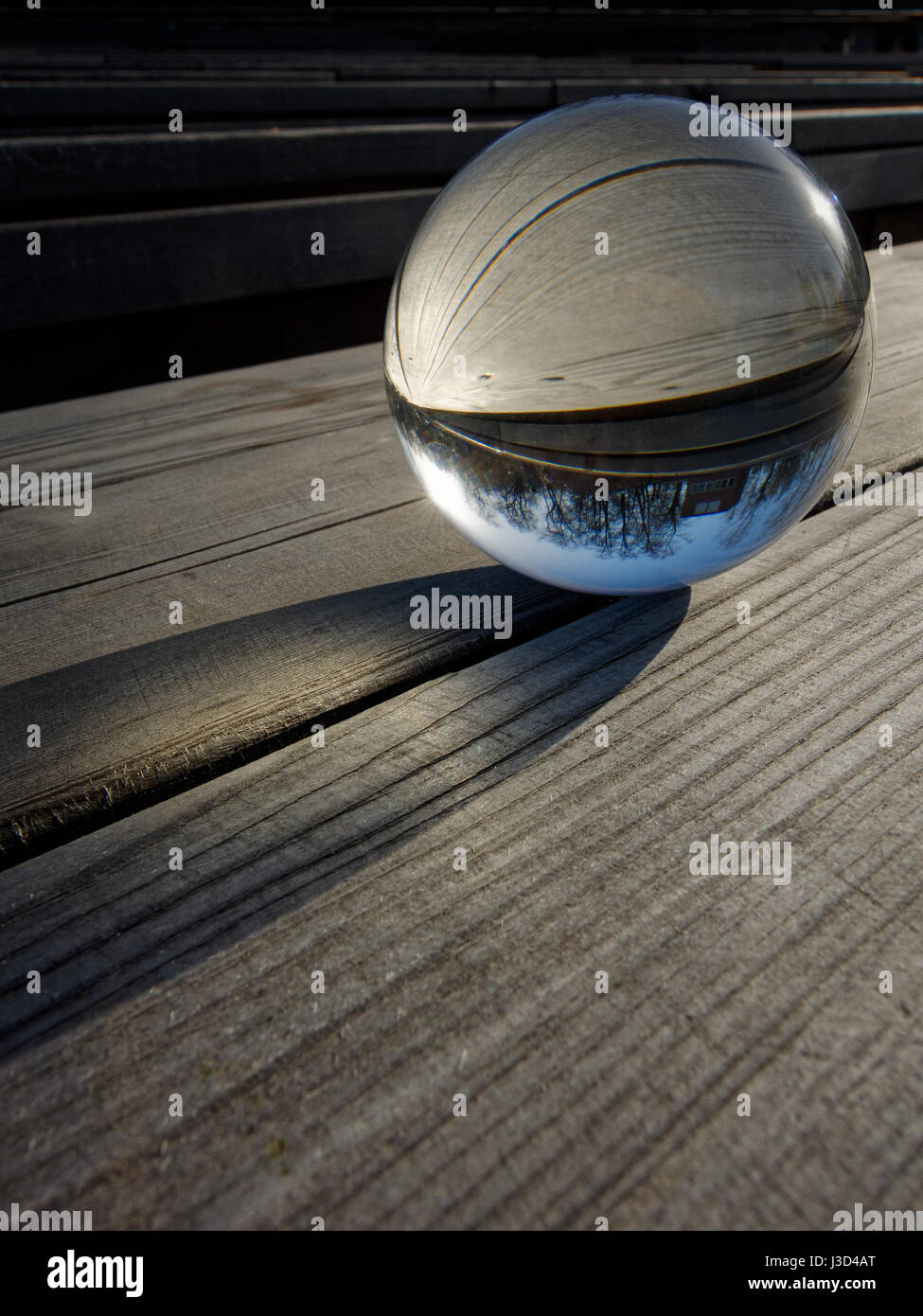 Backgrounds and textures: glass ball on a wooden table, part of a landscape inside Stock Photo
