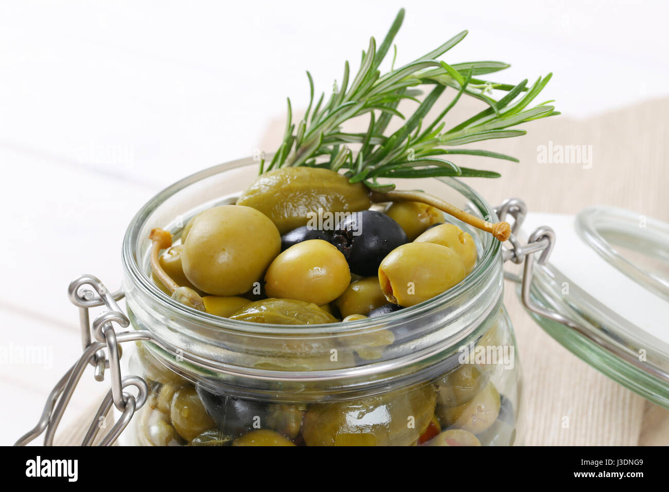 jar of pickled olives, capers and caper berries close up Stock Photo