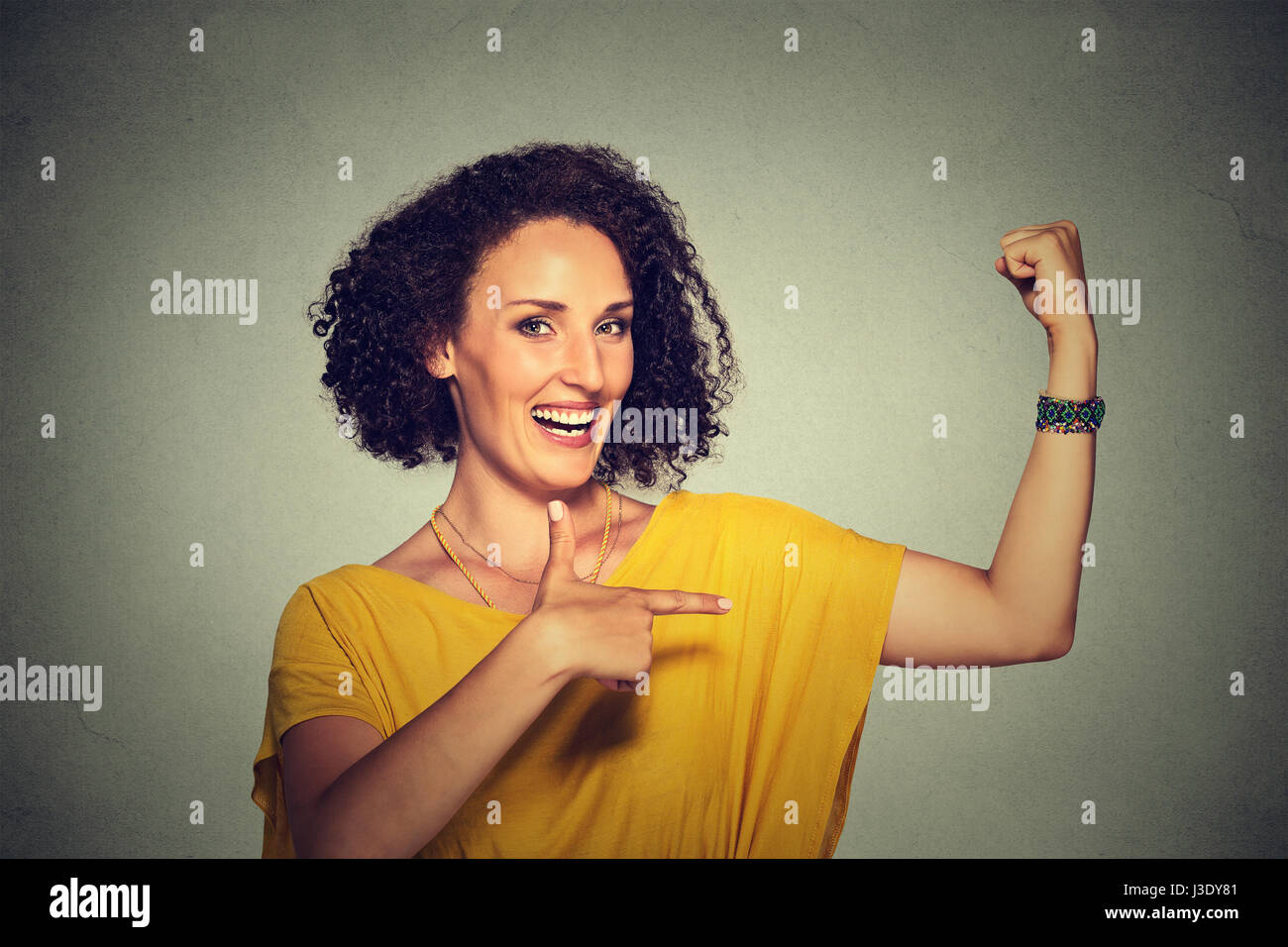 Closeup portrait fit middle aged healthy model woman flexing muscles confident showing her strength isolated on gray background. Positive emotion faci Stock Photo