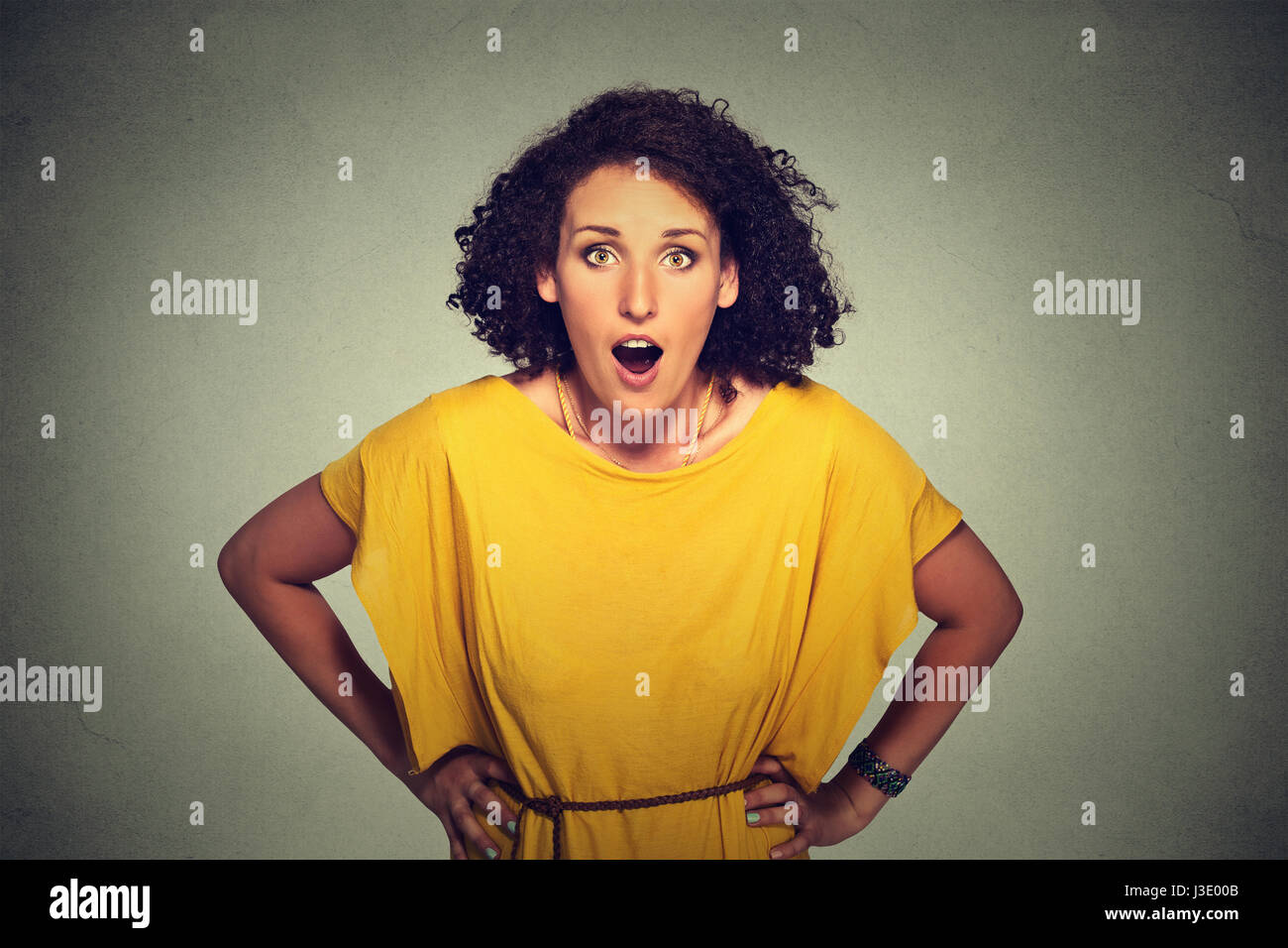 Surprised woman in yellow dress Stock Photo - Alamy