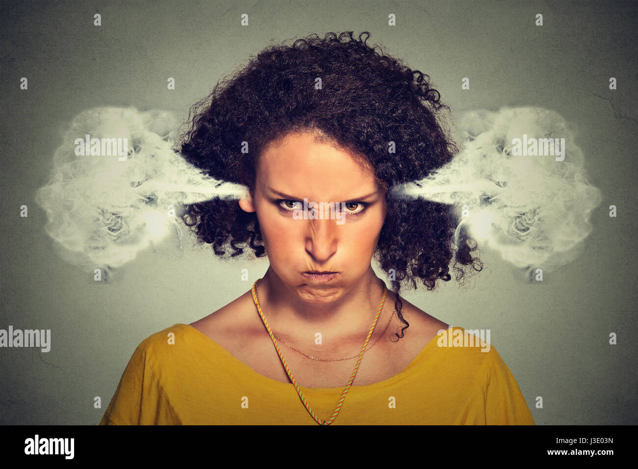 Closeup portrait of angry young woman, blowing steam coming out of ears, about to have nervous atomic breakdown, isolated gray background. Negative hu Stock Photo