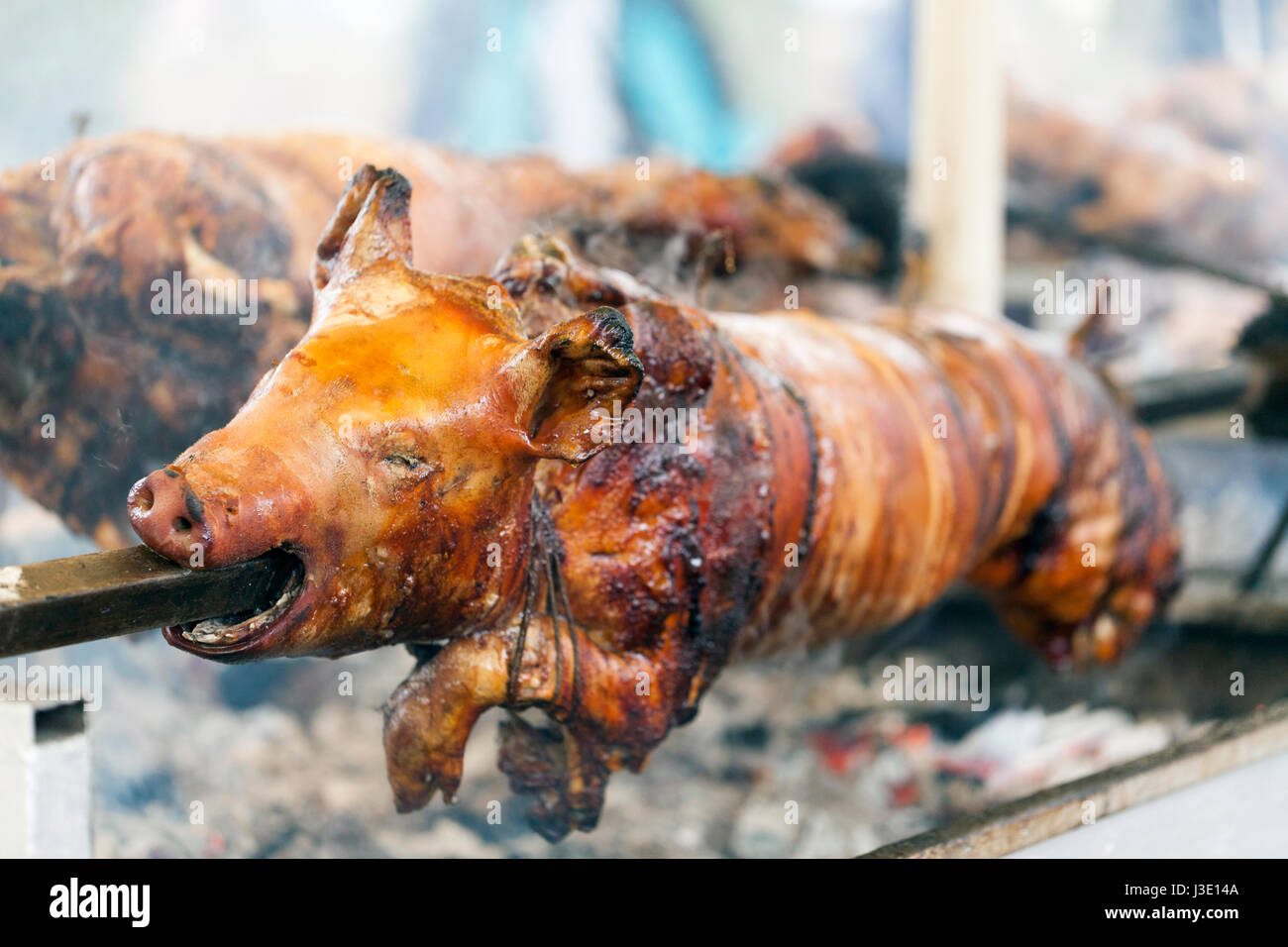 Traditionally suckling pig on a rotating spit with fire Stock Photo