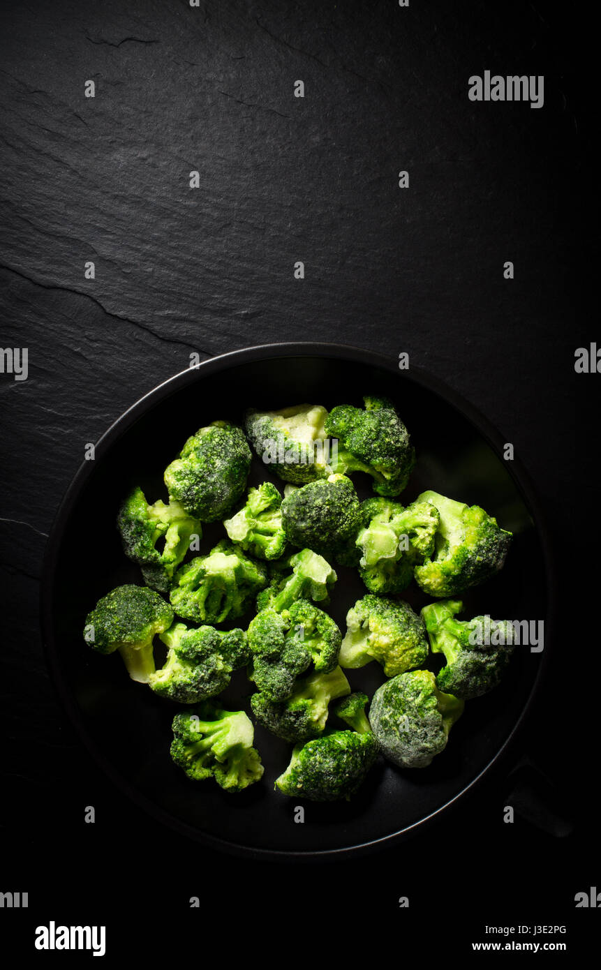 Frozen broccoli in black frying pan Stock Photo Alamy