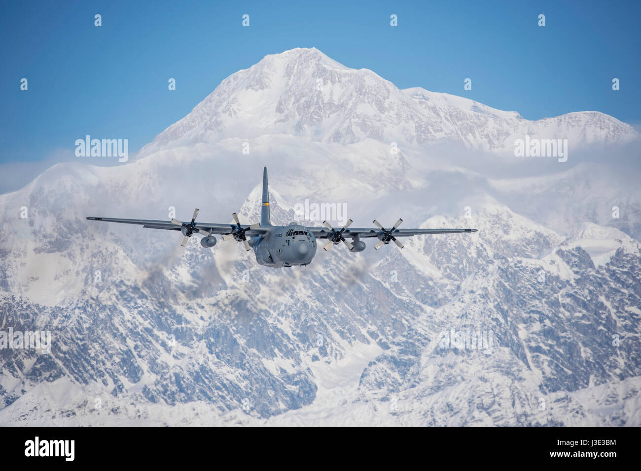 A U.S. Air National Guard C-130 Hercules transport aircraft flies away from Denali mountain March 4, 2017 in Alaska.    (photo by Edward Eagerton /US Air National Guard  via Planetpix) Stock Photo