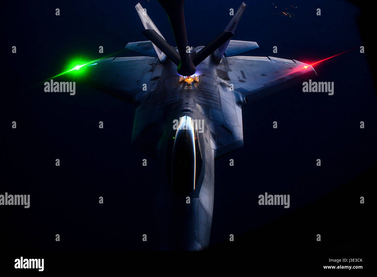 A USAF F-22 Raptor stealth tactical fighter aircraft refuels from a KC-135 Stratotanker aerial refueling aircraft at night over the Nellis Air Force Base Nevada Test and Training Range during the U.S. Air Force Weapons School Deliberate Strike Night June 16, 2016 near Las Vegas, Nevada.    (photo by Kevin Tanenbaum /US Air Force  via Planetpix) Stock Photo