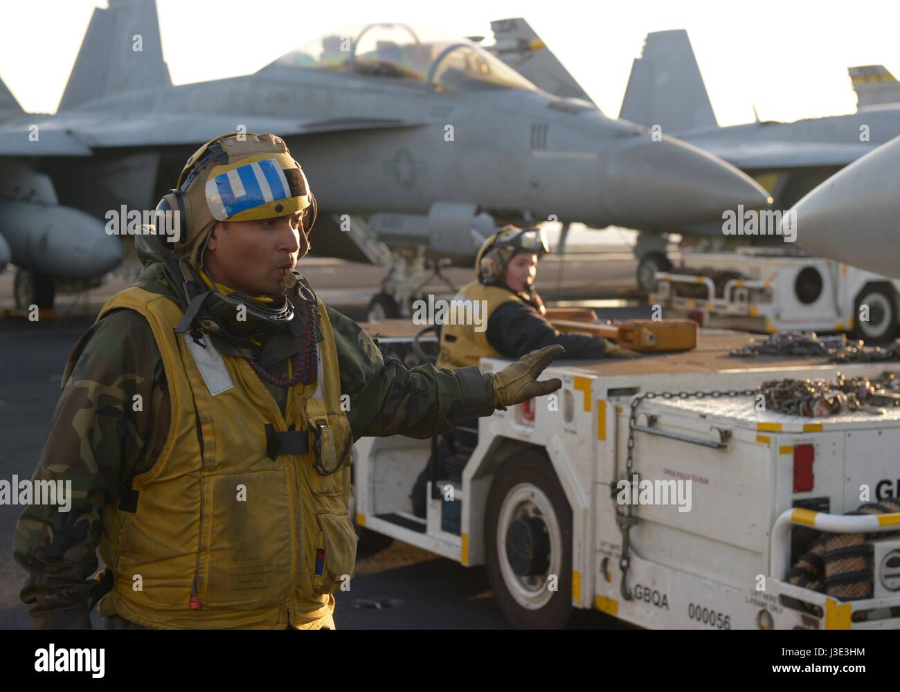 U.S. sailors move aircraft on the flight deck aboard the USN Nimitz ...