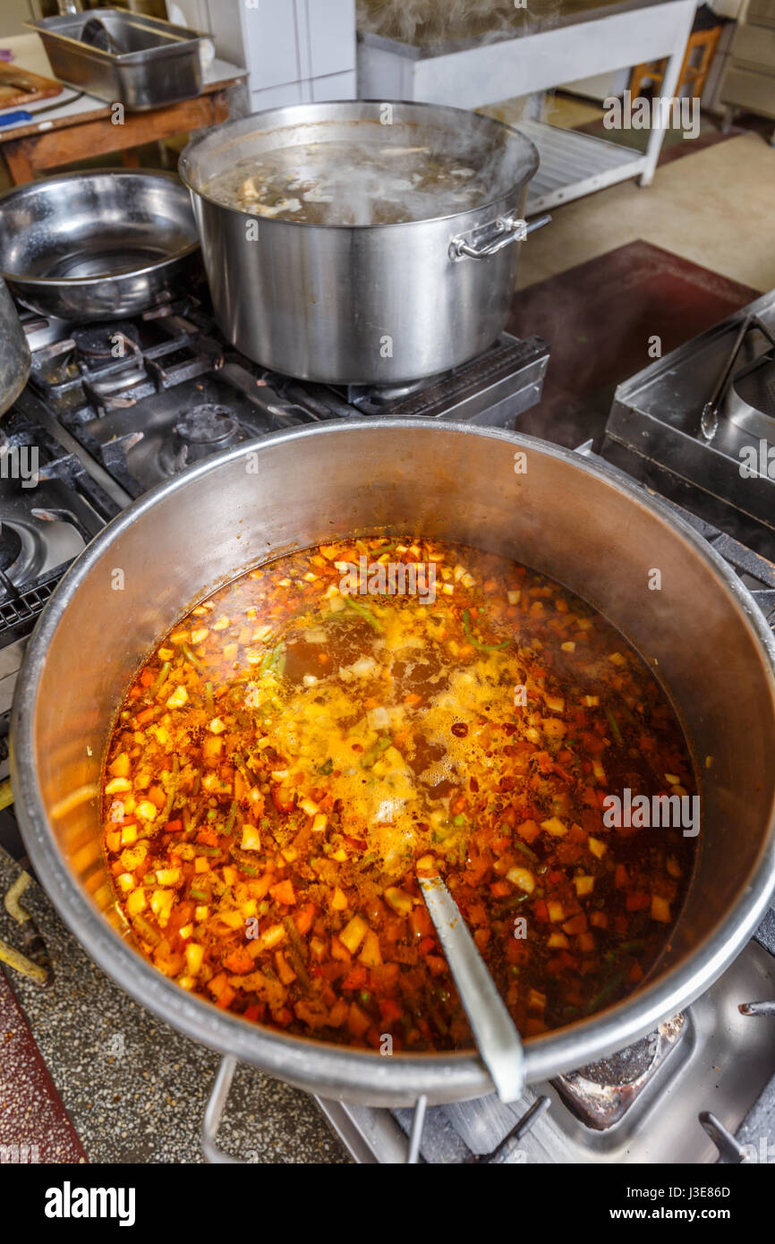 Several pots cooking on hotplate in professional kitchen Stock Photo