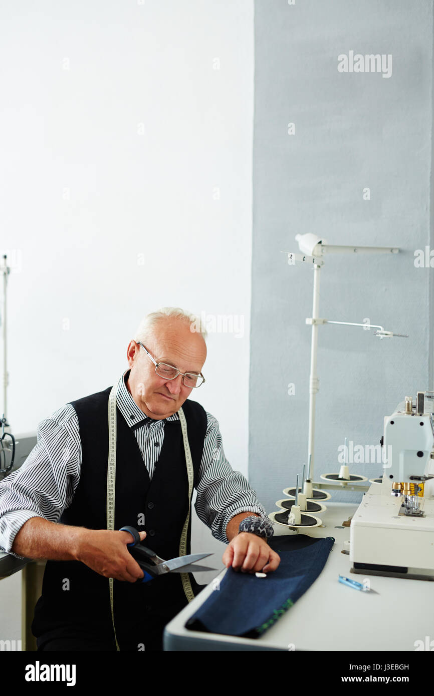 Old Tailor Working in Atelier Stock Photo