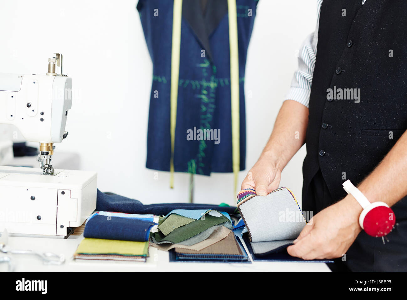 Tailor Choosing Fabric in Atelier Stock Photo