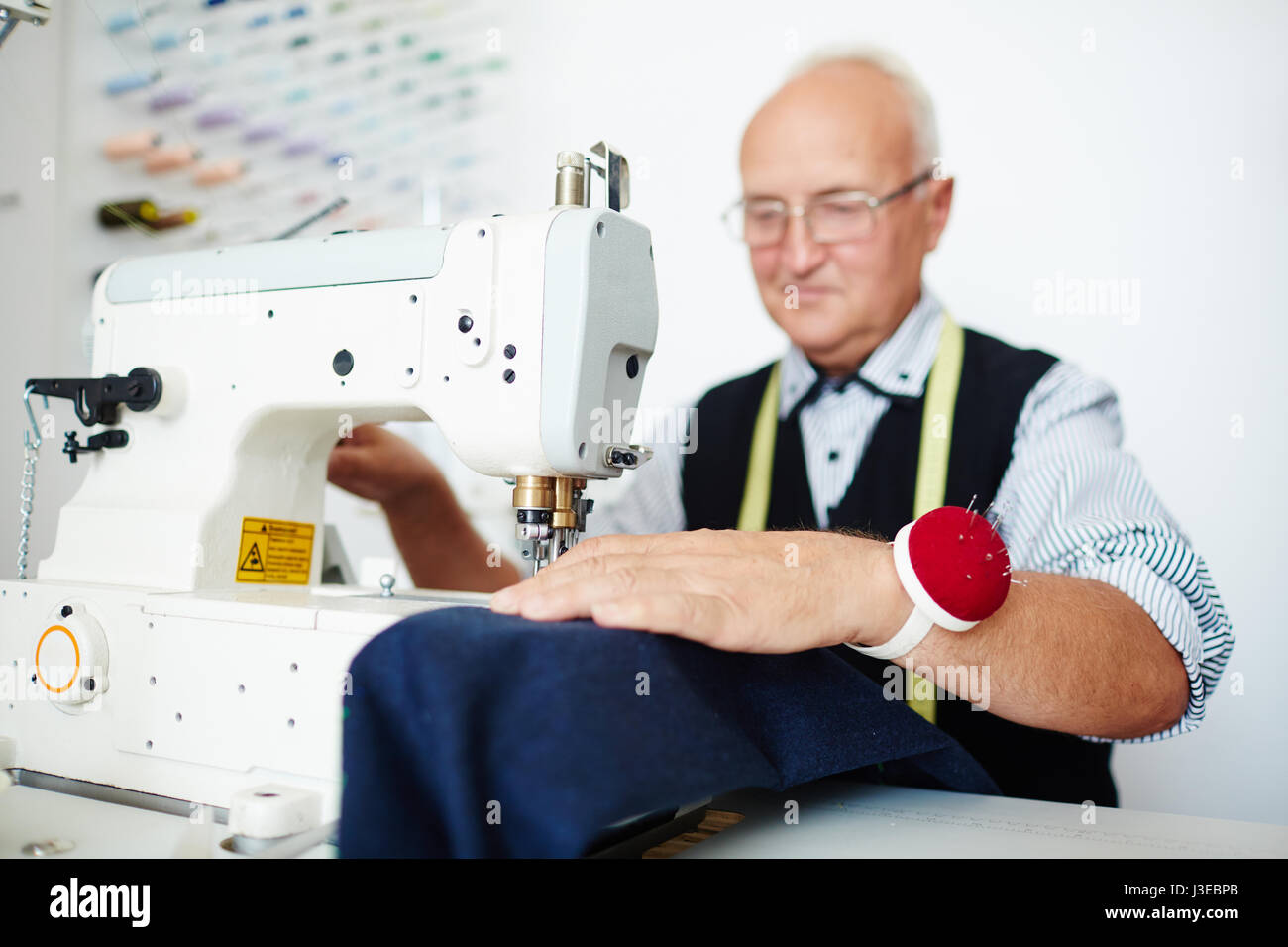 Happy Old Tailor in Workshop Stock Photo