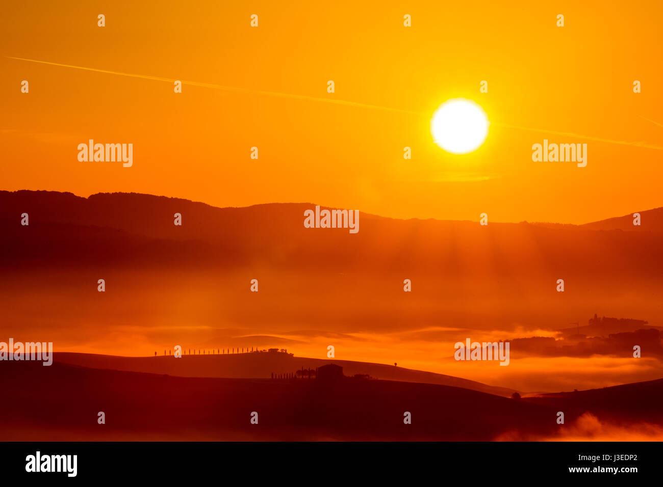Golden sunrise over the misty fields in Tuscany, Italy. Sun rays ...