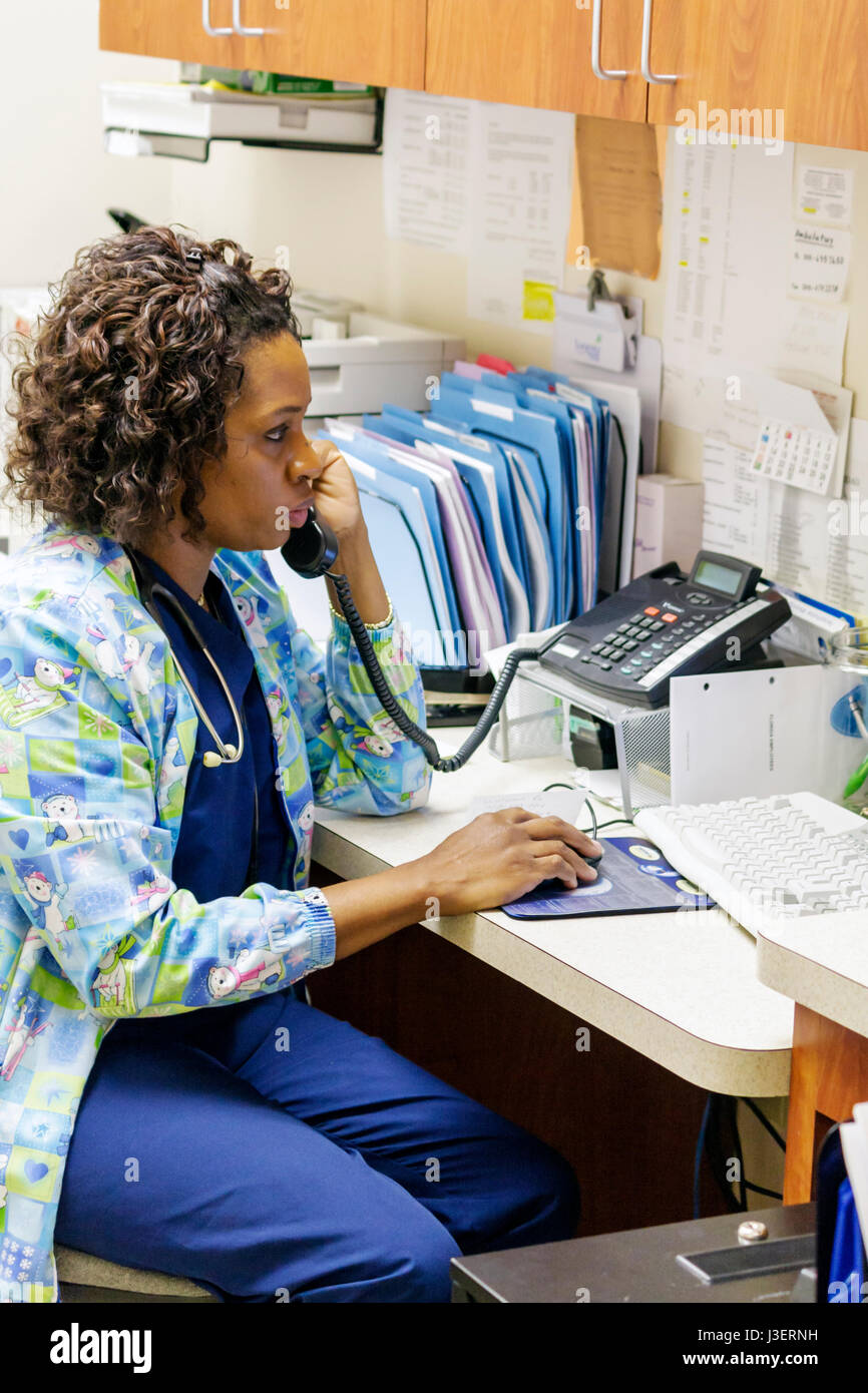 Miami Beach Florida,Mt. Mount Sinai,hospital,healthcare,office,phone,phones,medical assistant,Black woman female women,working,work,employee worker wo Stock Photo