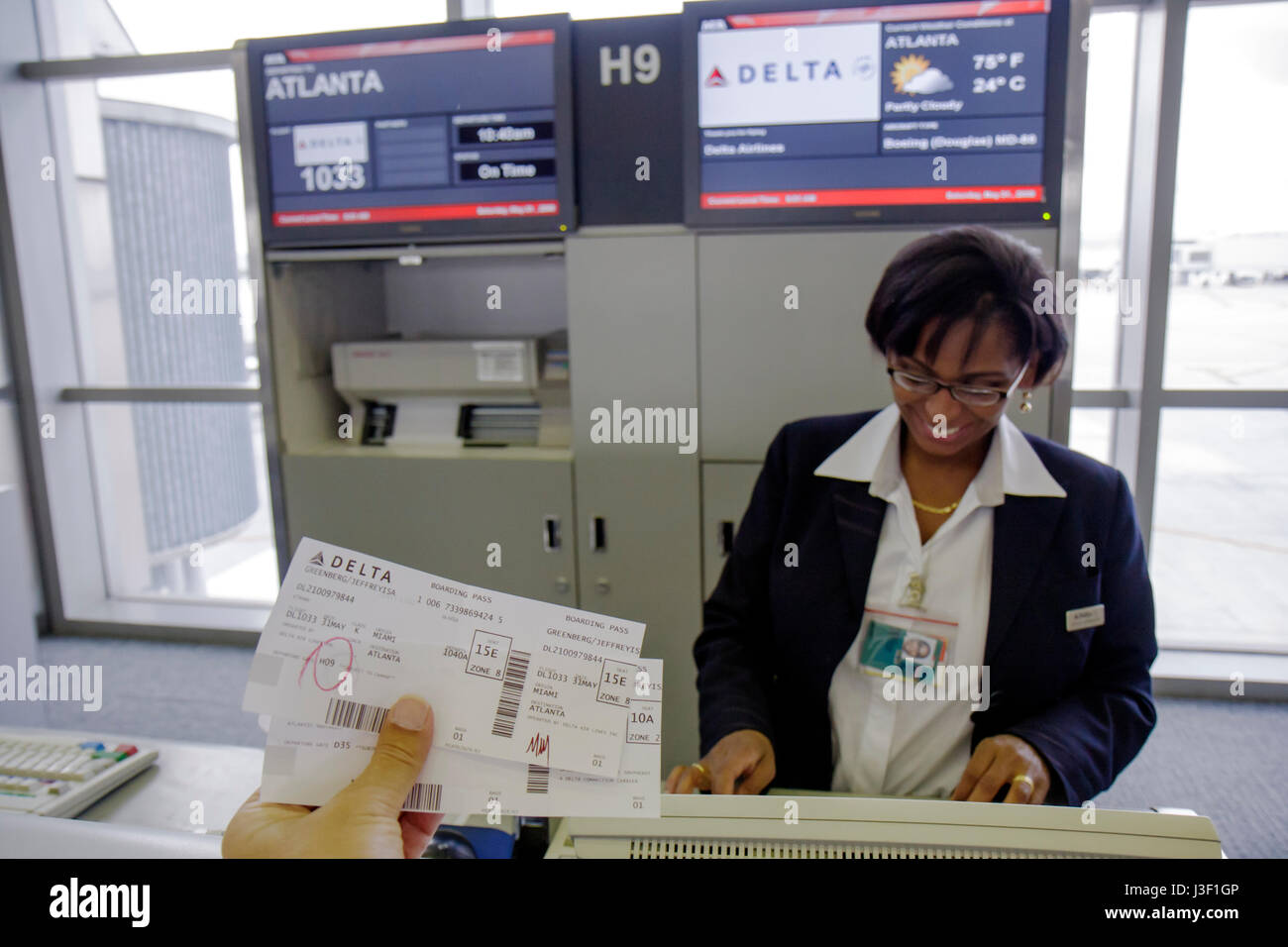 Miami Florida International Airport MIA,Black woman female women,ticket agent,Delta,boarding gate,flight,airline,customer service,pass,information,dep Stock Photo