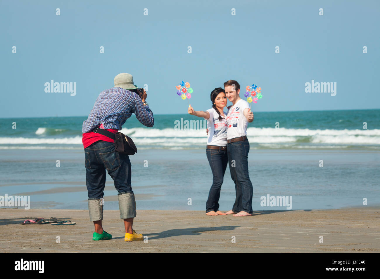 HUA HIN, THAILAND, MARCH 12, 2011 - Photographer taking a picture of multiracial couple on the Suan Son beach. Stock Photo